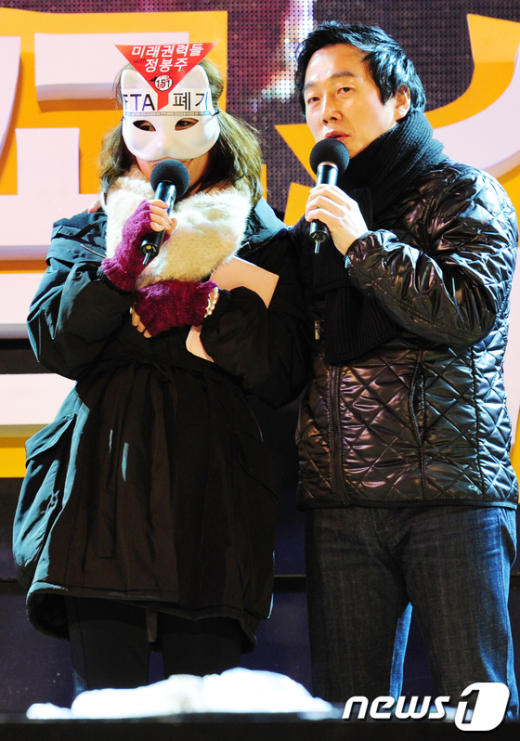 News1 30일 저녁 서울 영등포구 여의도 문화공원에서 인기 팟캐스트 '나는 꼼수다(나꼼수)'와 한미FTA 저지 범국민운동본부 주최로 열린 '나꼼수 FTA특별 야외공연'에서 마스크를 쓴 공지영 작가와 정봉주 전 민주당의원이 인사말을 하고 있다. 송원영 기자