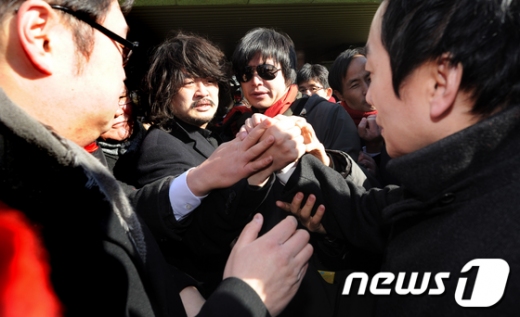 대법원 확정 판결로 구속 수감을 앞둔 인터넷방송 '나는 꼼수다'의 정봉주 전 의원이 26일 서울 서초동 검찰청사로 출석하며 멤버들과 작별 인사를 나누고 있다. 지난 2007년, 이명박 대통령이 BBK 주가조작에 연루됐다는 내용의 허위사실을 유포한 혐의(공직선거법 위반 등)로 징역 1년을 선고받은 정 전 의원은 구속 수감을 앞둔 이날 오전 국회에서 "오늘은 진실이 구속되지만 다음 차례는 거짓이 구속될 차례"라면서 "감옥에서 당당하게 굽히지 않고 쫄지 않고 진실을 위해 끝까지 싸우겠다"고 밝혔다.  News1   오대일 기자