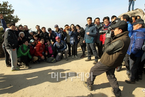 ↑이명박 대통령이 28일 청와대 직원과의 북악산 등반에서 직원들의 기념촬영을 하고 있는 모습.
