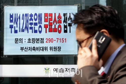 ↑예솔저축은행으로 이름을 바꿔 단 부산저축은행 초량본점 앞을 한 시민이 전화통화를 하며 지나가고 있다. ⓒ이기범 기자