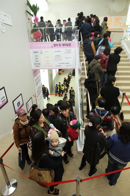 ↑지난달 30일 전북 군산시 수송동 810-5번지(롯데마트 건너편)에 오픈한 군산 지곡 쌍용 예가 모델하우스를 찾은 방문객들이 내부 관람을 위해 수십 미터 줄을 서고 있다.