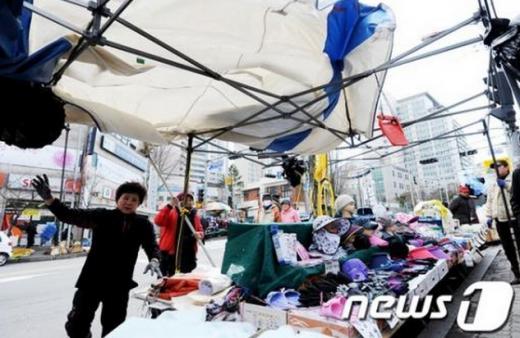3일 오후 경기도 고양시 일산시장의 상인들이 강한 바람에 뒤집힌 천막을 붙잡고 있다. (고양=뉴스1) 오대일 기자