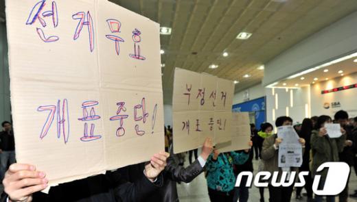 11일 저녁 서울 강남을 선거구 개표작업이 진행되고 있는 학여울역 서울무역전시장 개표소에서 봉인되지 않는 투표함이 발견되면서 민주통합당 정동영 후보 측 지지자들이 ‘선거무효, 개표중단’을 외치며 개표소 앞에서 항의를 하고 있다. 2012.4.11./뉴스1  News1   방인권 인턴기자
