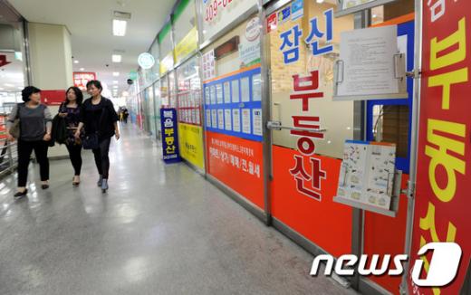정부가 강남3구(강남, 서초, 송파)를 비롯한 투기지역 해제와 분양권 전매제한 완화를 비롯한 주요내용의 '주택거래 정상화 및 서민-중산층 주거안정 지원방안'을 발표한 가운데 10일 시민들이서울 송파구 공인중개사무실 밀집지역에서 부동산 매매 시세표를 외면한 채 지나가고 있다. 2012.5.10/뉴스1 News1 박세연 기자