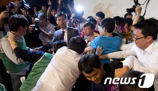 ↑지난 12일 경기 고양 일산 킨텍스에서 열린 통합진보당 2012 제1차 중앙위원회서 통합진보당 당권파 당원들이 의장석에 난입해 공동대표단에게 폭행을 행사하고 있다.