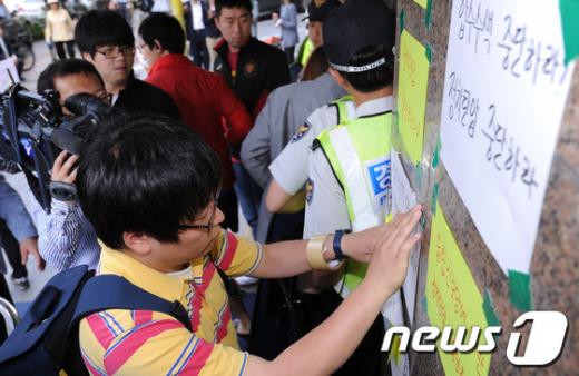 검찰이 통합진보당 비례대표 부정경선 의혹을 수사하기 위해 21일 서울 대방동 통합진보당사를 압수수색하고 있는 가운데 당원들이 검찰의 압수수색 중단을 요구하는 벽보를 붙이고 있다./사진=뉴스1(news1.kr) 양동욱 기자