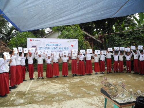 동양매직이 인도네시아 수카부미 지역에 마을과 강을 연결하는 파이프와 물탱크를 건설하는 지원 사업에 나섰다. 지난해 시설을 완공한 뒤 지역 주민들이 'THANK YOU TONGYANGMAGIC'이라고 적은 종이를 통해 동양매직에 고마움을 표현하고 있다.