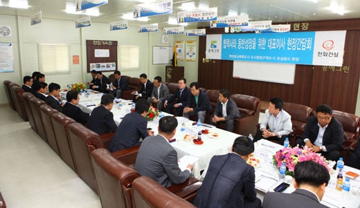 ↑한화건설 이근포 대표이사(뒷줄 우측에서 다섯번째)가 지난 22일 행정중심복합도시 도시행정구역(3-1) 조성공사 현장을 찾아 협력사 대표들과 대화를 나누고 있다. ⓒ한화건설 제공