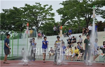 참가 학생들이 한국항공대 재학생들의 도움을 받아 만든 물로켓을 직접 쏘아 올리고 있다.