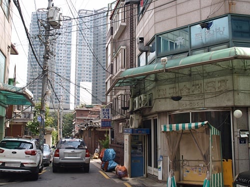 ↑ 서울시 성북구 하월곡동 집창촌 '미아리텍사스' 입구 사이로 36층 아파트 2개동이 높게 서 있다.ⓒ송학주