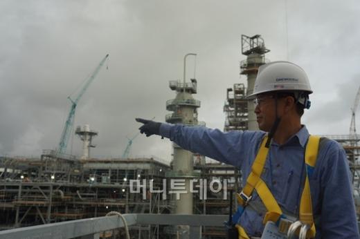 ↑지난 7월 20일 LNG프로세스 2기 철골설치가 완료돼 1년만에 LNG플랜트 2기의 철골설치가 완료됐다. 10월 17일 현재 건설 공정률은 56%. 사진은 김영후 현장소장(상무)가 대우건설이 짓고 있는 LNG플랜트 액화시설에 대해 설명하고 있는 모습.