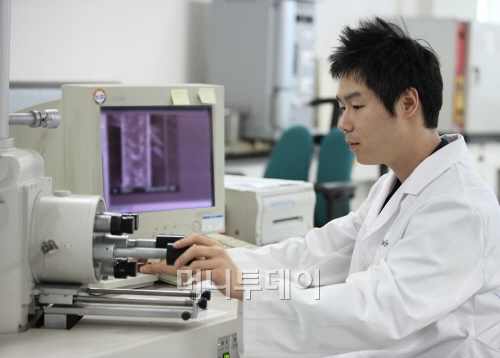 ↑휴비스 R&D센터에서 한 연구원이 섬유 원사 두께를 측정하고 있다.