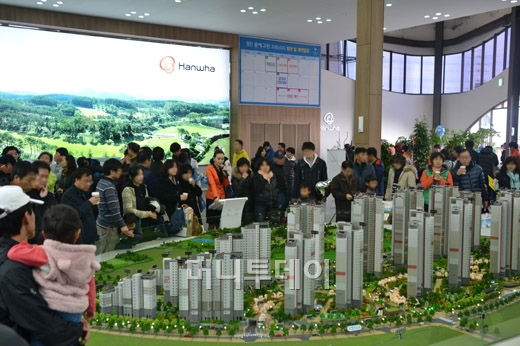 ↑한화건설이 동탄2신도시 시범단지 A21블록에 짓는 '동탄 꿈에그린 프레스티지' 모델하우스를 방문한 고객들이 단지 모형을 살펴보고 있다. ⓒ한화건설 제공