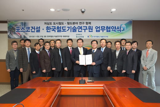 ↑포스코건설과 한국철도기술연구원은 27일 철도기술연구원에서'저심도 도시철도 연구협력'을 위한 협약을 체결했다. 포스코건설 유광재 사장(가운데 오른쪽)과 철도연 홍순만 원장(가운데 왼쪽)이 협약서를 들어 보이고 있다. ⓒ사진=포스코건설 제공