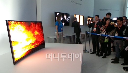 삼성전자가 지난 8일(현지시간)부터 11일까지 미국 라스베이거스에서 열린 세계 최대 가전전시회(CES)에 전시한 커브드 OLED TV. 관람객들이 사진을 촬영하며 제품을 보고 있다.