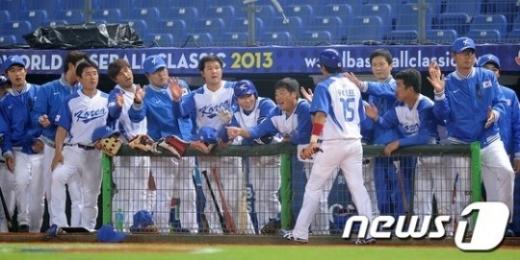 ↑월드베이스볼 클래식(WBC) 한국 야구대표팀이 지난달 28일 오후 대만 타이중 인터콘티넨탈 구장에서 대만 실업선발팀을 상대로 연습경기를 가졌다. 한국 1회말 1사 2루 상황 김태균의 우중간안타때 2루주자 이용규가 홈을 밟은 후 더그아웃 앞에서 동료선수들과 하이파이브를 나누고 있다. ⓒ 뉴스1=타이중(대만) 이동원 기자