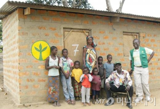 콩고민주공화국 카상굴르군의 새마을회 소속 주민들이 지난해 집 짓기 사업을 마친 뒤 기념촬영하고 있다./사진= 새마을운동중앙회 제공