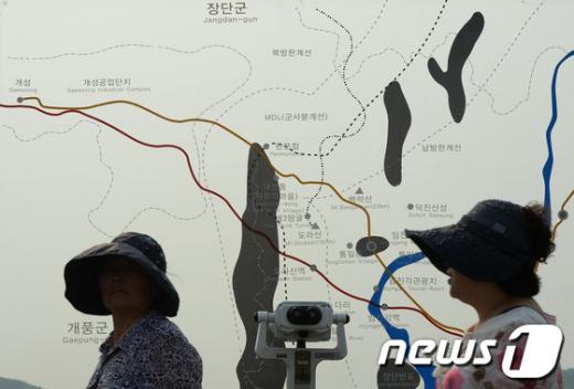 7일 오후 경기 파주 임진각의 남북 비무장지대와 개성공단의 위치를 알리는 지도 앞으로 시민들이 지나고 있다. 정부는 "북측의 판문점 실무접촉 제의에 동의해 9일 오전 10시 판문점 우리측 지역에서 실무회담을 갖자"는 입장을 전달했으며, "이날 오후 2시부터 끊어졌던 판문점 통신선도 재개됐다"고 밝혔다. 남북의 이번 실무접촉과 장관급 회담이 성사될 가능성이 커짐에 따라 개성공단, 금강산 관광, 이산가족 문제 등 현안문제 해결에 전환점이 될 것으로 기대된다. 2013.6.7/뉴스1  News1   양동욱 기자