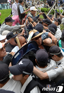 어버이연합 등 보수단체 회원들이 지난 8일 서울 광화문 광장에서 열린 22회 민족민주열사·희생자 범국민 추모제 개최를 반대하며 행사장 진입을 시도하자 경찰이 막아서고 있다./뉴스1