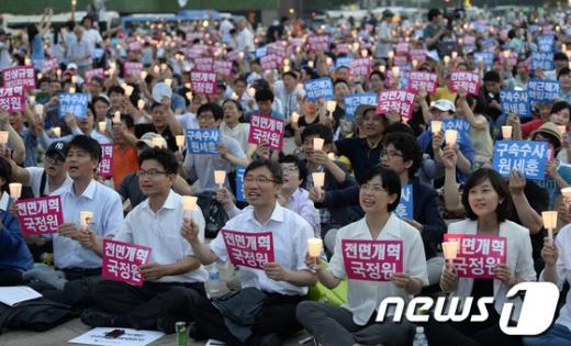 6일 오후 서울광장에서 시민사회단체 주최로 열린 "국정원 대선개입 진상규명 촉구 범국민대회"에서 이정희 통합진보당 대표, 김재연 의원을 비롯한 참석자들이 촛불을 들고 있다. 2013.7.6/뉴스1  News1 박지혜 기자