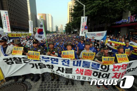 애국단체총협의회 회원 등이 6일 오후 서울 청계광장에서 열린 국가반역 공모세력심판 기자회견에서 "NLL포기는 영해포기다"라고 적힌 손피켓을 들고 있다.2013.7.6/뉴스1  News1 이광호 기자
