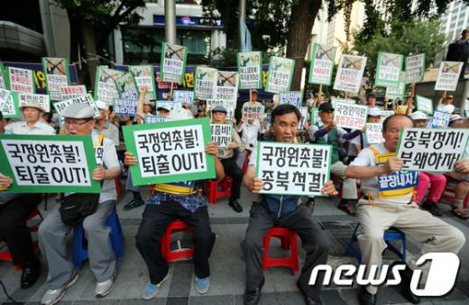 보수시민단체 애국주의연대 회원 등이 6일 오후 서울 시청역 앞에서 열린 국정원 해체 촛불집회 반대 기자회견 및 NLL사수 순국장병 촛불추모제에서 구호를 외치고 있다.2013.7.6/뉴스1  News1 이광호 기자