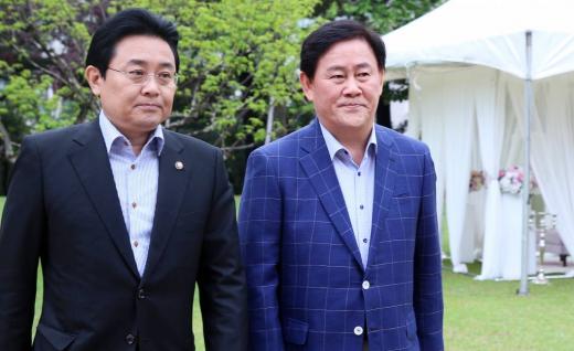 (서울=뉴스1) 오대일 기자 = 새누리당 최경환 원내대표와 민주당 전병헌 원내대표가 5월 19일 서울 여의도 국회 사랑재에서 열린 원내대표 취임 후 첫 공식회동에 앞서 의원동산을 산책하고 있다. 두 원내대표 배경으로 이날 예정된 한 예비 부부의 예식장 신부대기실이 보여 이채롭다. 2013.5.19/뉴스1