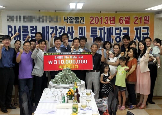 경매에서 낙찰받은 물건을 매각한 후 투자자들과 배당지급 행사를 하고 있는 이상규 리더스옥션 대표(앞쪽 왼쪽에서 네번째)./사진제공=리더스옥션