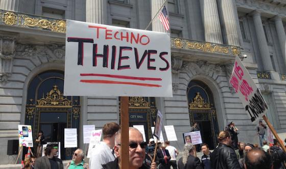 지난달 30일 샌프란시스코 시청 앞에서 차량공유서비스에 반대하는 택시 노조원들이 '테크노 도둑들'이라는 피켓을 들고 시위를 벌이고 있다. <사진출처:테크크런치>
