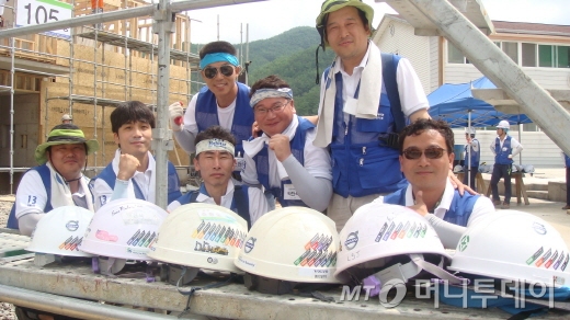 사랑의 집짓기 행사에 다년간 참가한 볼보건설기계 직원들. 안전모에 붙은 스티커는 그동안 참여한 횟수를 나타낸다. /진주(경남)=양영권 기자