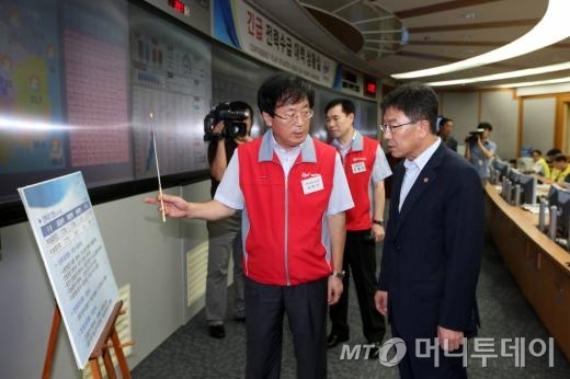 (서울=뉴스1) 한재호 기자 = 윤상직 산업통상자원부 장관이 8일 오전 서울 강남구 삼성동 전력거래소 긴급 전력수급 대책 상황실을 찾아 남호기 전력거래소 이사장으로부터 전력 상황에 대한 보고를 받고 있다. 윤 장관은 이어서 열린 '전력 위기극복 긴급 현장대책 회의'에서