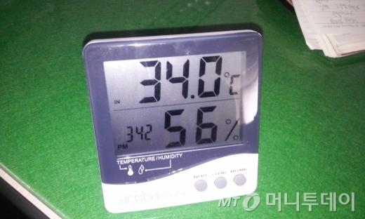12일 오후 한전 사무실에 있는 온도계가 34도를 나타내고 있다. 조명이 모두 꺼져, 사진을 찍자 자동플래시 기능이 작동했다/김평화 기자