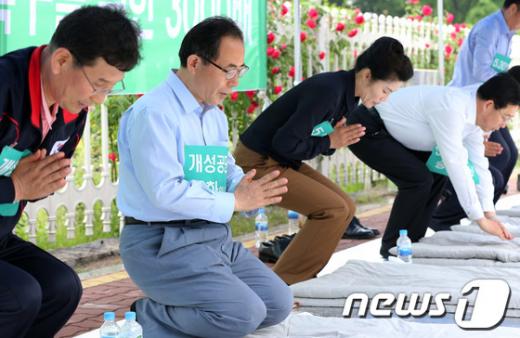 29일 서울 여의도 국회의사당 정문 앞에서 민주당 김성곤-한정애 의원이 개성공단 입주기업 관계자들과 함께 "개성공단 정상화를 위한 3천배"를 하고 있다. 2013.5.29/뉴스1  News1   오대일 기자