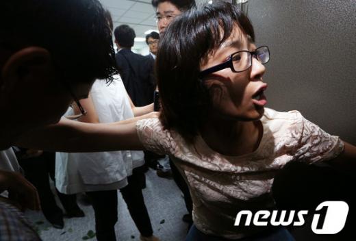 국가정보원과 검찰이 내란예비음모 등 혐의로 이석기 통합진보당 의원의 주거지 등 10곳에 대해 전격 압수수색을 실시한 28일 오전 서울 여의도 국회 의원회관 이석기 의원 사무실에서 한 여성 보좌진이 집행관들의 진입을 막고 있다. 2013.8.28/뉴스1  News1   오대일 기자