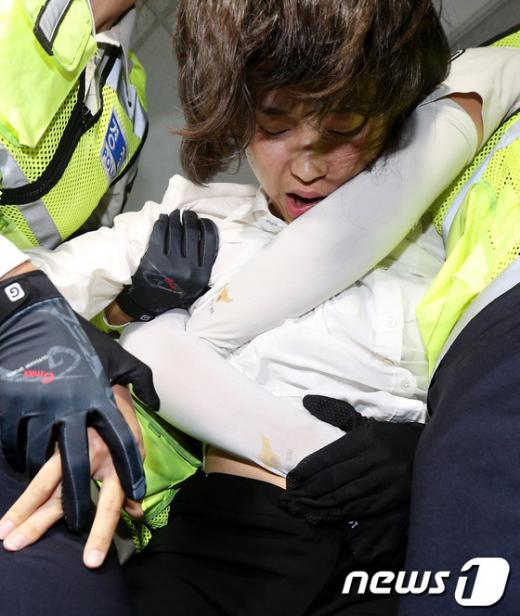 통합진보당 김재연 의원이 4일 저녁 국회 의원회관에서 이석기 의원 강제구인에 나선 국정원 직원들과 대치하다 여경들에 의해 끌려나오고 있다. 2013.9.4/뉴스1  News1   오대일 기자