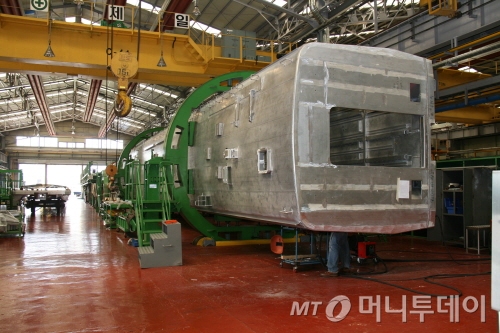 초록색의 원통으로 이뤄진 '회전지그'가 6면의 프레임을 360도로 돌려줘 용접의 정교함을 더해준다./사진제공=현대로템