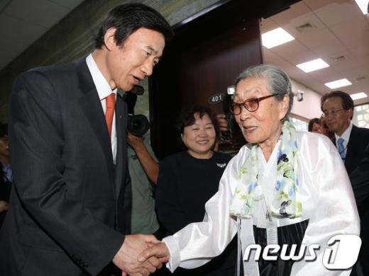 윤병세 외교부장관이 14일 오후 서울 여의도 국회에서 열린 외교통일위원회 국정감사에 참고인 자격으로 출석한 김복동 위안부 피해자 할머니와 인사를 나누고 있다. 가운데는 인재근 민주당 의원./뉴스1