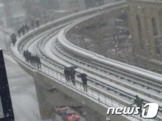 지난해 12월 폭설로 의정부 경전철의 운행이 중단되자 시민들이 선로를 걸어서 탈출하고 있다./사진=뉴스1