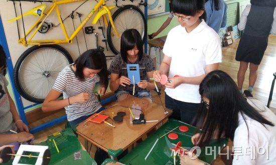 경남 고성군 고성읍에 위치한 고성여중 학생들이 기술공작실 프로그램에 참여해 직접 자동차 모형을 제작하고 있다./사진=한국산업기술진흥원 제공