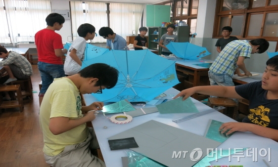 부산 사상구 삼락동에 위치한 삼락중 학생들이 기술공작실 프로그램에 참여해 직접 광섬유가 부착된 우산을 만들고 있다./사진=한국산업기술진흥원 제공