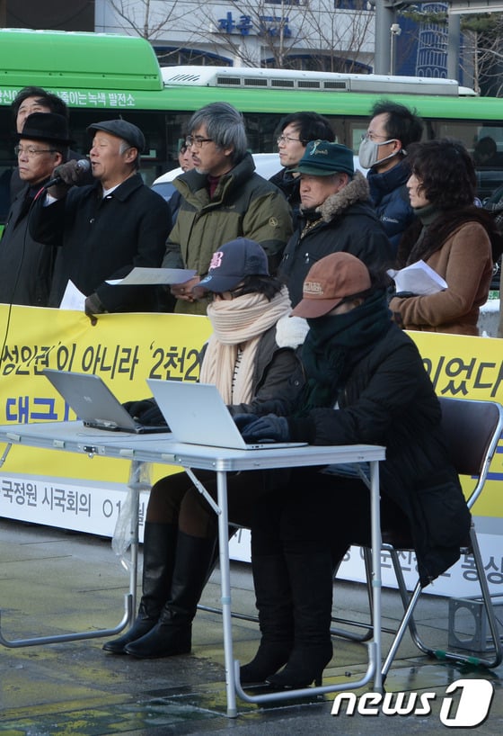 국정원 시국회의 회원들이 지난 11일 서울 광화문광장에서 연 '국정원 댓글사건 1년, 시국회의 기자회견'에서 일부 참가자들이 국정원 댓글녀로 불리는 여성의 복장을 한 채 노트북을 만지는 퍼포먼스를 하고 있다./뉴스1