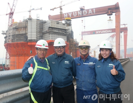 현대중공업이 건조 중인 세계 최대 부유식 FPSO 옆으로 갑오년 해가 떠오르고 있다. 오른쪽으로 세계 최대 크레인인 '말뫼의 눈물'이 보인다./사진=홍봉진 기자