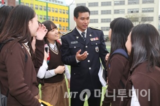 문승민 서울서부경찰서 학교폭력전담경찰관(경사)이 서울 충암중학교 운동장에서 학생들과 이야기를 나누고 있다./사진=이동훈 기자