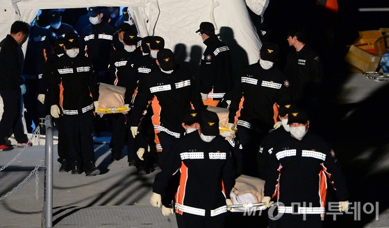 (진도=뉴스1) 양동욱 기자 세월호 여객선 침몰 사고 발생 엿새째인 21일 오후 전남 진도 팽목항 선착장에서 고인들의 시신이 운구되고 있다.<br><br>이날 상당수 실종자들이 갇혀 있을 것으로 추정된 세월호 3~4층에서 시신이 다수 발견됐다. 2014.4.21/뉴스1