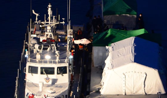 (진도=뉴스1) 양동욱 기자 세월호 여객선 침몰 사고 발생 7일째인 22일 전남 진도군 팽목항에서 희생자들의 시신이 운구되고 있다./ 사진=뉴스1
민·관·군 합동구조팀은 이날 오전 6시30분부터 해경 경비함 90척을 포함한 선박 239척, 항공기 37대, 잠수부를 포함한 755명을 투입해 대대적인 수색작업을 벌였다. 2014.4.22/뉴스1