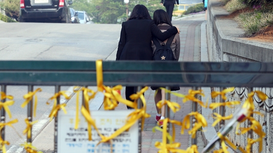 단원고등학교 여학생이 교사의 위로를 받으며 등교하고 있는 모습. /사진=뉴스1 허경 기자.