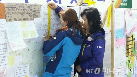 전남 진도군 팽목항에서 실종자 가족들이 무사생환을 기원하는 노란리본에 글을 적고 있다./사진=머니투데이 김민우 기자.