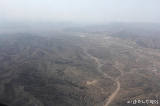 중국 네이멍구자치구 바우터우 지역 하늘에서 비행기를 타고 바라본 지상의 모습. 미세먼지가 두꺼운 층을 형성했다./사진=김평화 기자