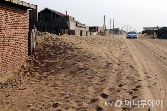몽골 자민우드 지역. 사막에서 날아온 모래가 쌓여 담벼락 높이까지 올라왔다.