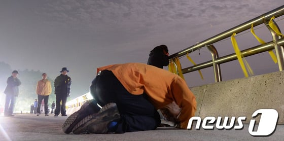 세월호 침몰사고 29일째인 14일 오전 전남 진도군 어두운 팽목항에서 실종자 가족이 밤바다를 향해 큰절을 하고 있다. /사진=뉴스1